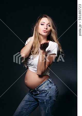 Gorgeous expectant mother with naked tummy blowing Gorgeous expectant mother with naked tummy blowing 50180723