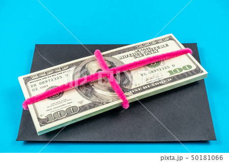 Prop Money Dollars and black envelope.Light blue background Prop Money Dollars and black envelope.Light blue background 50181066