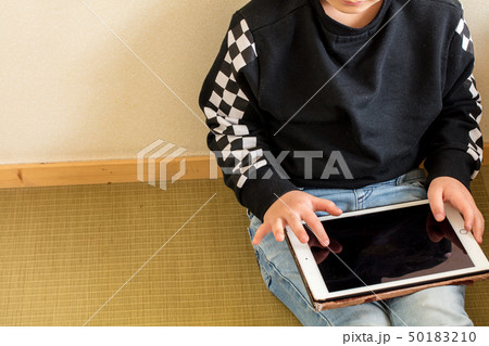 小学生の男の子がタブレットを持って遊んでいる学習している勉強現代時代 50183210