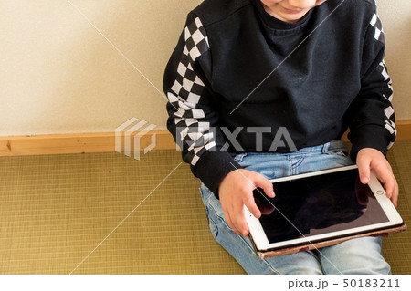 小学生の男の子がタブレットを持って遊んでいる学習している勉強現代時代 50183211