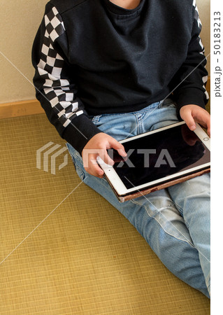 小学生の男の子がタブレットを持って遊んでいる学習している勉強現代時代 50183213