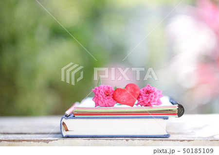 Red heart and notebooks on wooden table 50185109