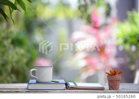 White cup with plant and notebooks 50185260