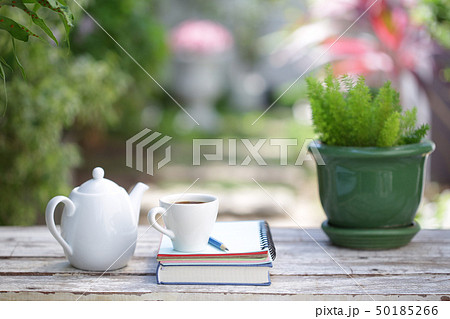 White coffee cup and notebooks on wooden table  50185266