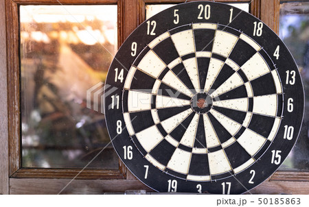 close up vintage dart board against wooden window 50185863