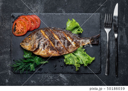 Grilled dorada on a black stone tray served food 50186039