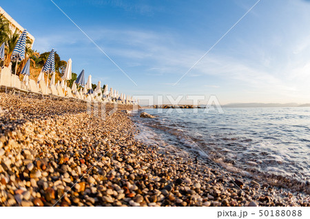 Summer sunrise on coast, Corfu island, Greece. Beach with Sunbeds and umbrellas with perfect views Summer sunrise on coast, Corfu island, Greece. Beach with Sunbeds and umbrellas with perfect views 50188088