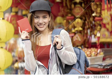 Young asian woman traveler bag backpacker holding red passport f 50188672