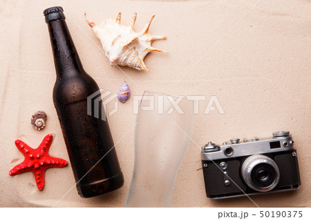 Beer bottle and glass on a sandy beach. Beer bottle and glass on a sandy beach. 50190375