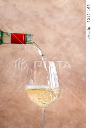 White wine pouring into glass 50194166