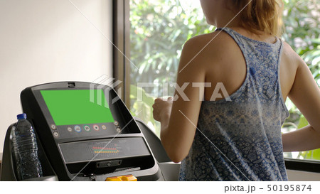 Young caucasian girl running on the treadmill in the sport gym 50195874