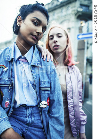 Two teenage girls infront of university building smiling, having fun, lifestyle real people concept Two teenage girls infront of university building smiling, having fun, lifestyle real people concept 50197540