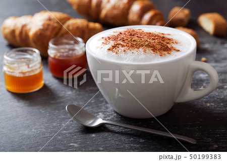 cup of cappuccino coffee on dark table 50199383