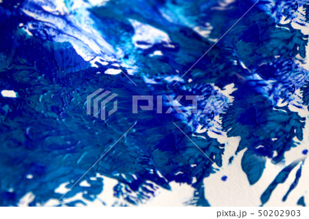 Strokes of blue paint on white paper background or texture 50202903