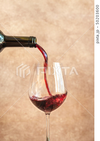 Red wine pouring into glass 50203600