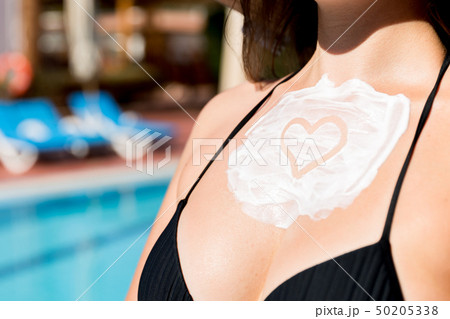 Pretty woman is applying sun cream 50205338