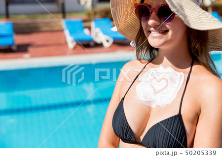 Pretty woman is applying sun cream Pretty woman is applying sun cream 50205339