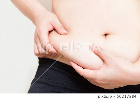 お腹のお肉をつまむ女性 お腹のお肉をつまむ女性 50217884