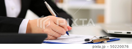 Hand of businesswoman filling and signing Hand of businesswoman filling and signing 50220076