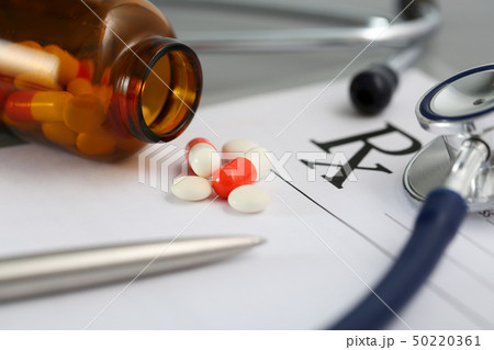 Prescription lying on table with stethoscope, pen and pile of pills Prescription lying on table with stethoscope, pen and pile of pills 50220361