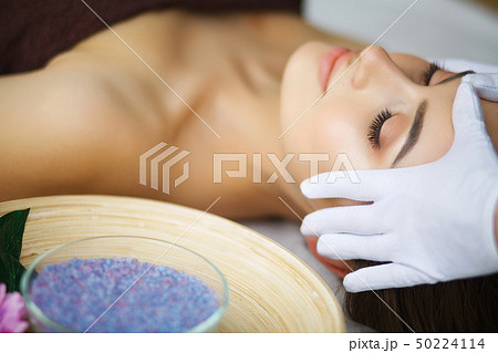 Masseur doing massage the head of an woman in spa salon Masseur doing massage the head of an woman in spa salon 50224114