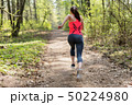 Active woman running in spring sunny forest 50224980