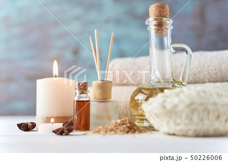 Towels, candle and massage oil on white table 50226006