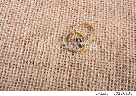 Two diamond rings on a textured background Two diamond rings on a textured background 50226136