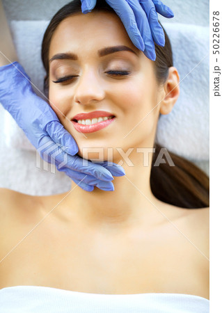 Skin and care. Beautiful Young Woman with Pure and Beautiful Skin in Spa Salon. Massage for the face Skin and care. Beautiful Young Woman with Pure and Beautiful Skin in Spa Salon. Massage for the face 50226678