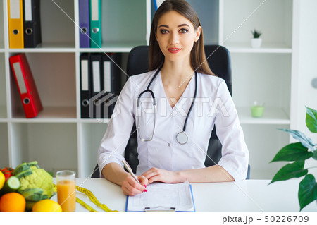 Health. Young Woman Dietitian Sitting At A Table With Fresh Fruits And Vegetables.High Resolution 50226709