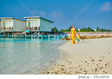 Toddler boy on beach with mother 50228050