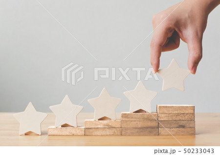Hand putting wooden five star shape on table 50233043