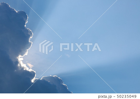 light rays of sun shine through big cloud 50235049
