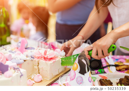 Woman's hands cut decorated with marshmallow cake, marshmallows on holiday party 50235339