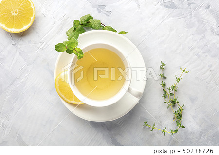 A cup of green tea with lemon, shot from the top with mint, thyme, and a place for text A cup of green tea with lemon, shot from the top with mint, thyme, and a place for text 50238726