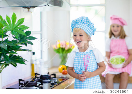 Kids cook in white kitchen. Children cooking. Kids cook in white kitchen. Children cooking. 50241604