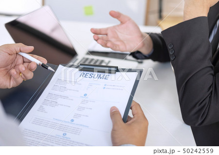 Employer or recruiter holding reading a resume Employer or recruiter holding reading a resume 50242559