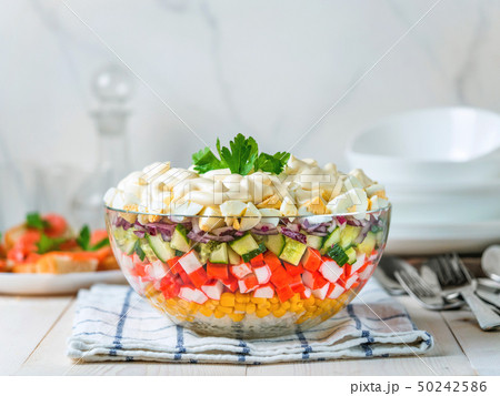 Layered crab salad with corn, cucumber, rice Layered crab salad with corn, cucumber, rice 50242586