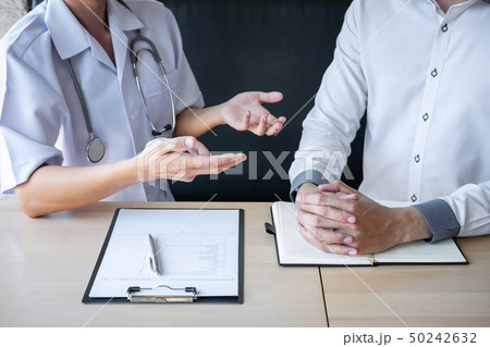 Doctor consulting with patient examining for 50242632