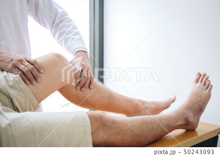 Doctor physiotherapist assisting a male patient Doctor physiotherapist assisting a male patient 50243093