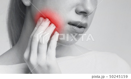 Young woman feeling toothache touching her cheek 50245159
