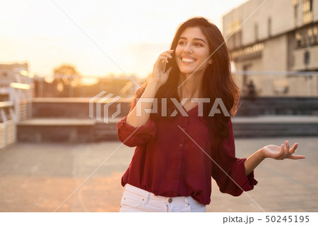 Beautiful woman having phone talk outdoors, walking in city Beautiful woman having phone talk outdoors, walking in city 50245195