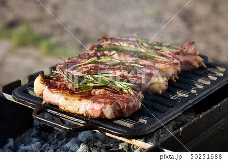 Juicy beef steaks cooking on grill outdoors Juicy beef steaks cooking on grill outdoors 50251688