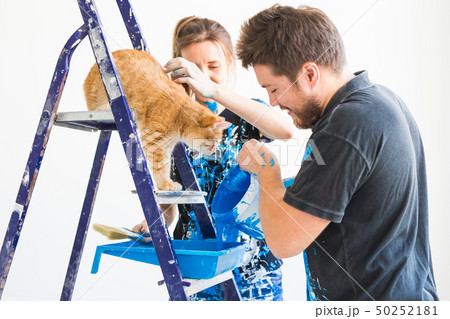 People, renovation and repair concept - portrait of happy couple with cat pour paint 50252181