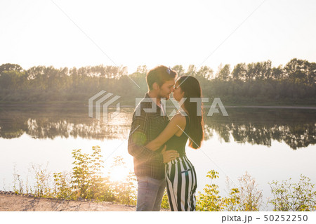 Love, romantic and nature concept - young couple hugging near the lake 50252250