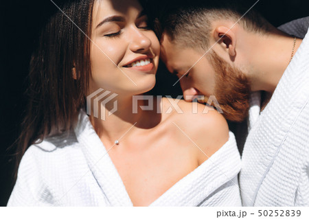 Young man gently kissing beautiful woman on shoulder 50252839