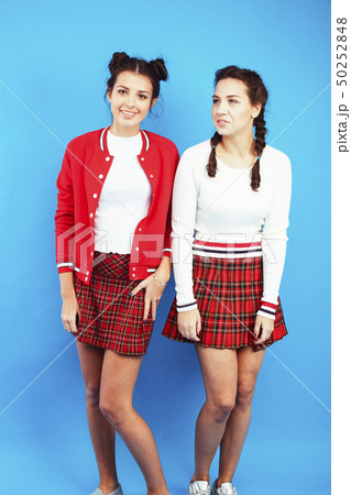 best friends teenage school girls together smiling having fun, posing emotional on blue background best friends teenage school girls together smiling having fun, posing emotional on blue background 50252848