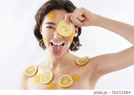 Funny smiling woman with many lemon pieces Funny smiling woman with many lemon pieces 50252984