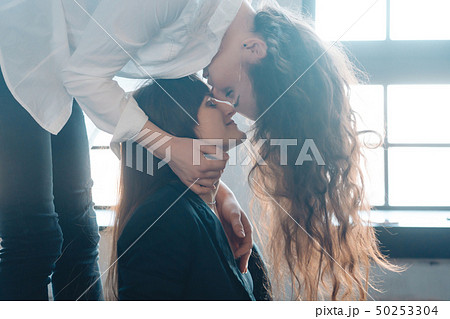 Close up young woman thoughtfully kissing woman at home Close up young woman thoughtfully kissing woman at home 50253304