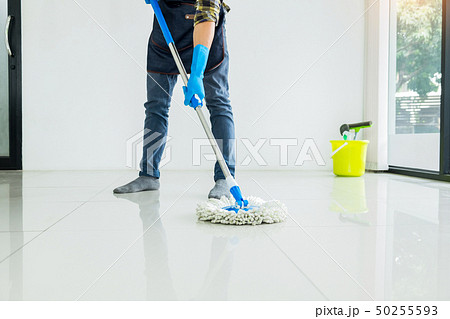 Young housekeeper cleaning floor mobbing holding 50255593